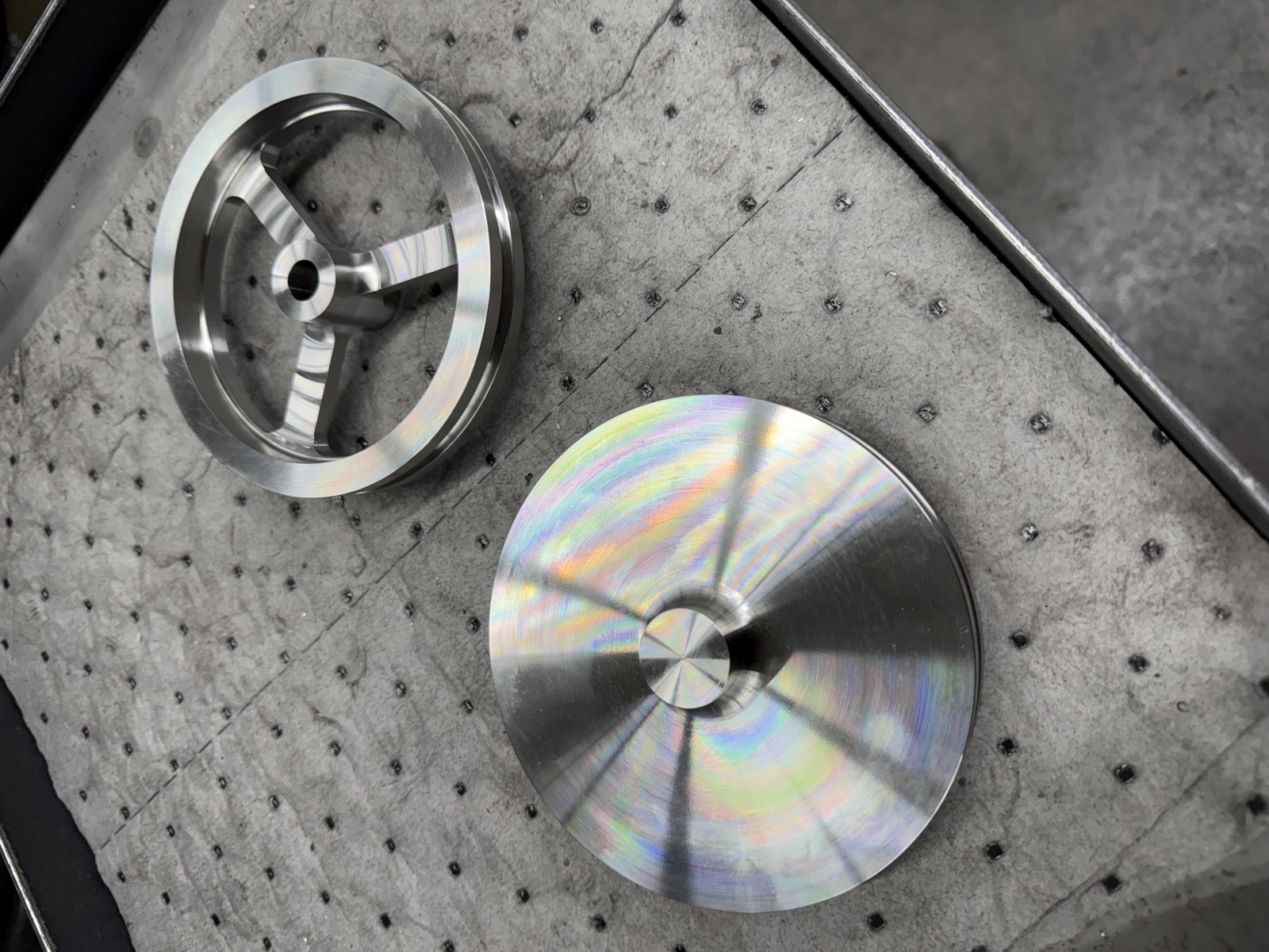The same stainless part at two stages: turned on the lathe, then milled into a three-spoke wheel